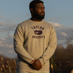 Male standing wearing Taylor University crew neck.