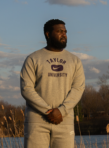 Male standing wearing Taylor University crew neck.